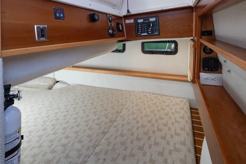 Slide: The Image of 2023 Cutwater C-30 Sedan cabin interior with bed, wood paneling, and control panels. - 41