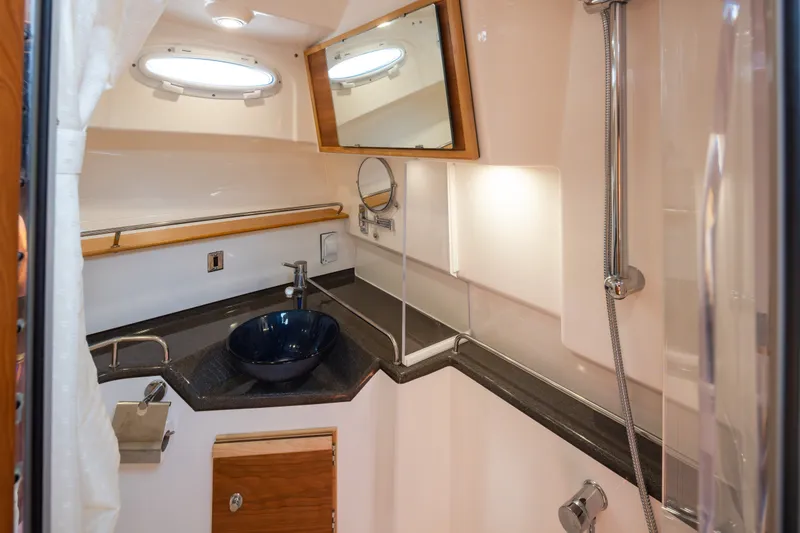 Slide: The Image of 2023 Cutwater C-30 Sedan bathroom with modern sink, shower, and mirror. - 39