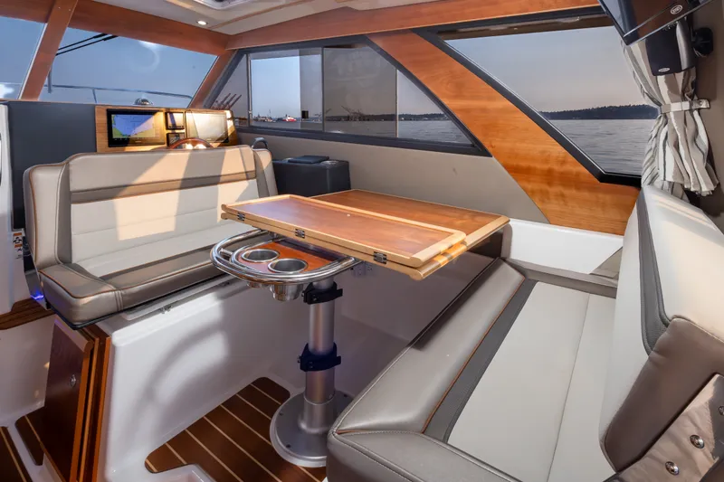 Slide: The Image of 2023 Cutwater C-30 Sedan interior with elegant seating and wooden table, featuring scenic window views. - 27