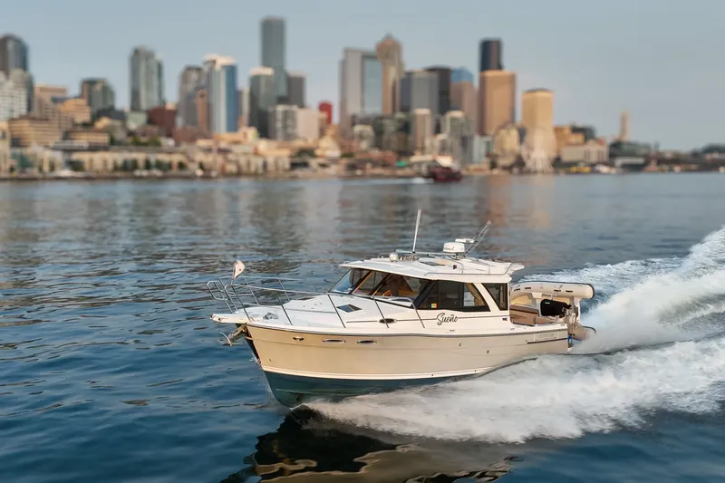 Slide: The Image of 2023 Cutwater C-30 Sedan cruising on water with city skyline in background. - 15
