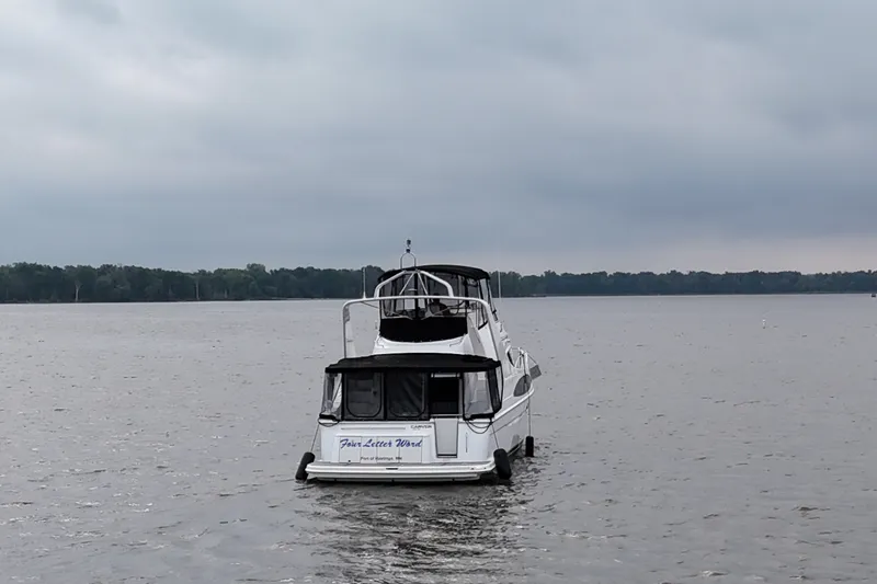 Slide: The Image of 2002 Carver 410 Sport Sedan yacht on a calm lake under cloudy skies. - 5