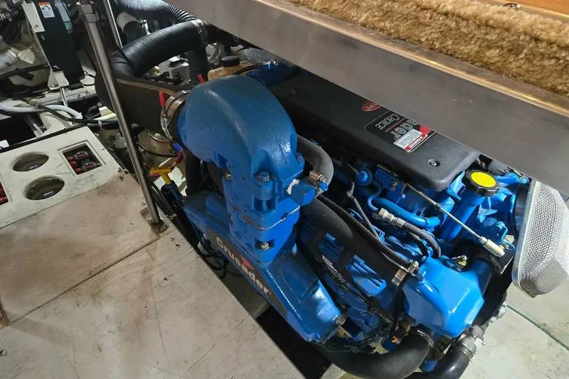 Slide: The Image of Engine compartment of a 2002 Carver 410 Sport Sedan, featuring a blue marine engine. - 28