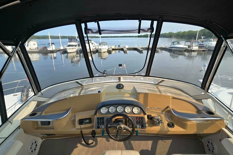 Slide: The Image of Interior view of 2002 Carver 410 Sport Sedan yacht at marina, showcasing helm and dashboard. - 19