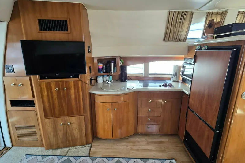 Slide: The Image of Interior of 2002 Carver 410 Sport Sedan with wood cabinetry, TV, and kitchenette. - 6