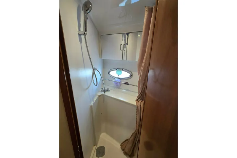 Slide: The Image of Shower area in 2002 Carver 410 Sport Sedan yacht, featuring a sleek design and porthole window. - 15