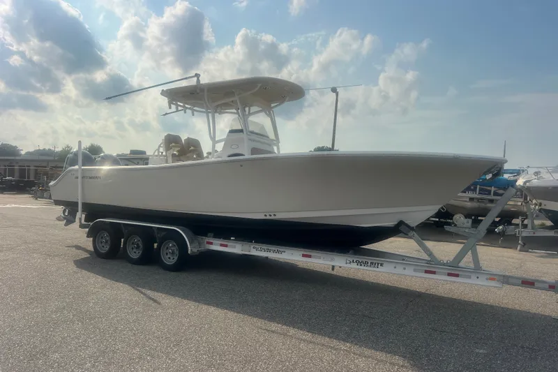 Slide: The Image of 2017 Sportsman Open 282 Center Console boat on trailer under cloudy sky. - 12