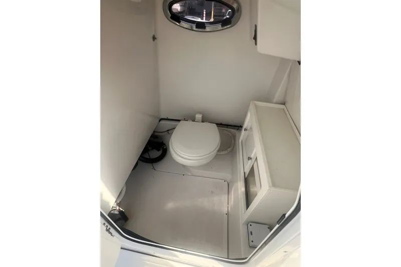 Slide: The Image of 2017 Sportsman Open 282 Center Console boat interior with toilet and storage cabinet. - 25
