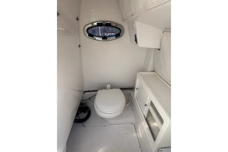 Slide: The Image of Interior of 2017 Sportsman Open 282 Center Console boat with compact marine toilet. - 26
