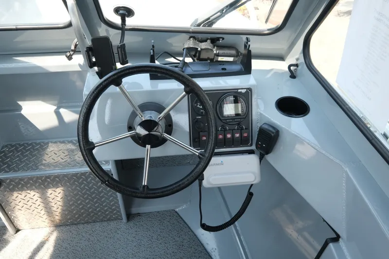Slide: The Image of 2023 Hewescraft 180 Sportsman boat dashboard with steering wheel and control panel. - 8