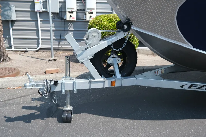 Slide: The Image of Trailer hitch of a 2023 Hewescraft 180 Sportsman boat, parked on pavement. - 15