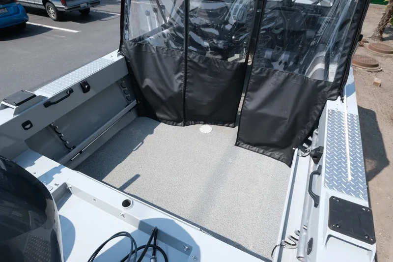 Slide: The Image of 2023 Hewescraft 180 Sportsman boat interior with protective covers and spacious deck. - 14