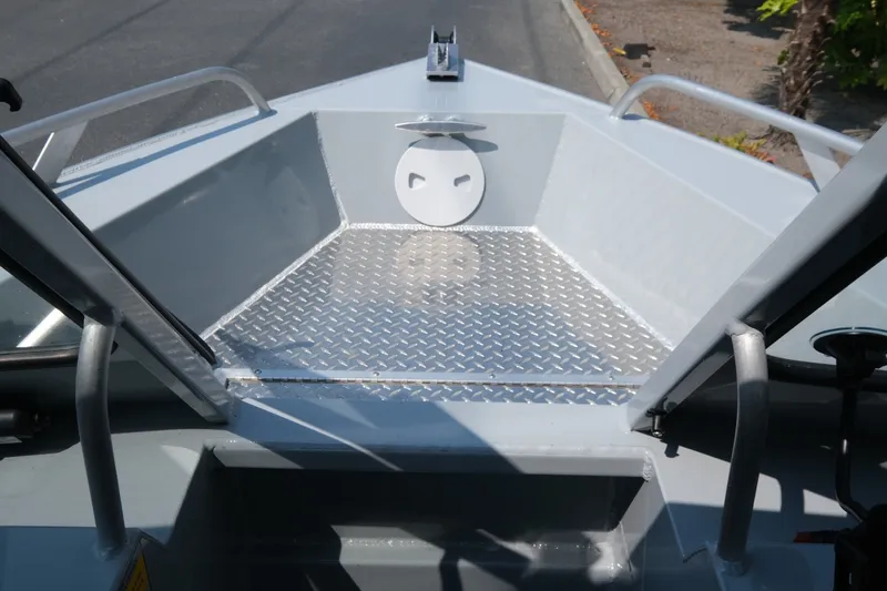 Slide: The Image of 2023 Hewescraft 180 Sportsman boat interior with diamond plate flooring and open bow design. - 6
