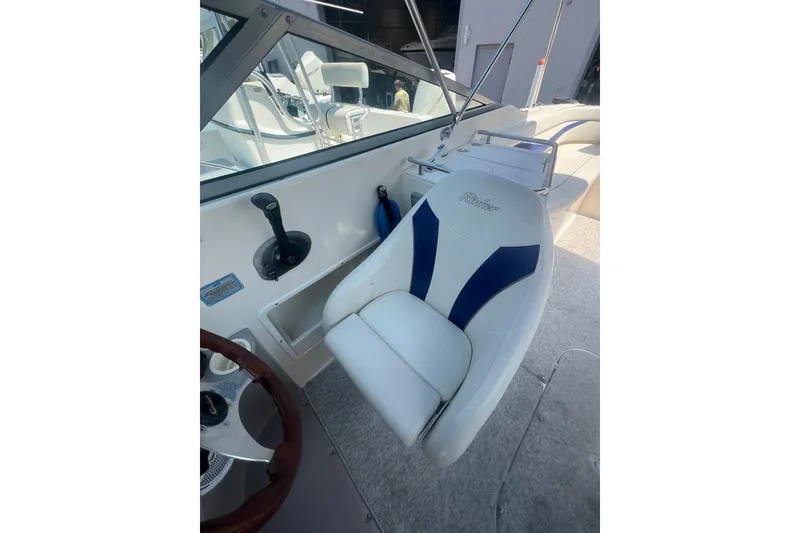 Slide: The Image of 2004 Rinker 282 Captiva Bowrider cockpit with white and blue seating. - 50