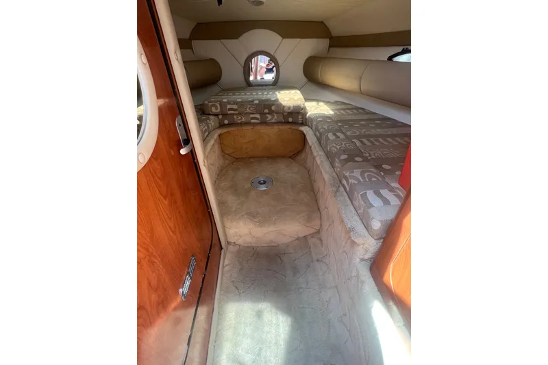 Slide: The Image of Interior cabin of 2004 Rinker 282 Captiva Bowrider with cushioned seating and wooden door. - 42