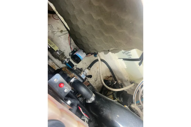Slide: The Image of Engine compartment of a 2004 Rinker 282 Captiva Bowrider with visible hoses and components. - 35
