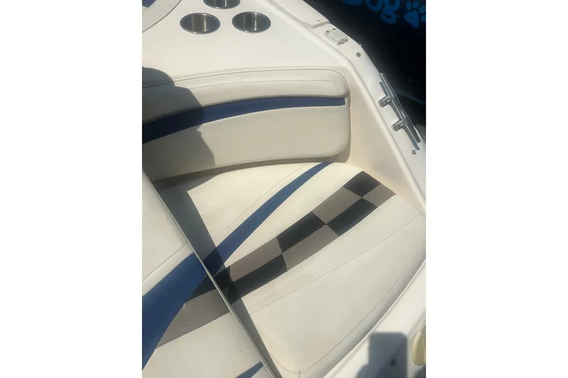 Slide: The Image of 2004 Rinker 282 Captiva Bowrider interior with white and blue seating, cup holders visible. - 54
