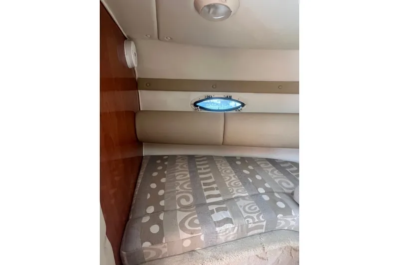Slide: The Image of Interior cabin of 2004 Rinker 282 Captiva Bowrider with patterned upholstery and porthole. - 46