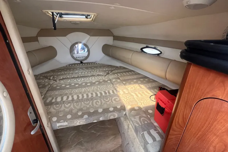 Slide: The Image of Interior cabin of a 2004 Rinker 282 Captiva Bowrider with patterned cushions and a small window. - 24
