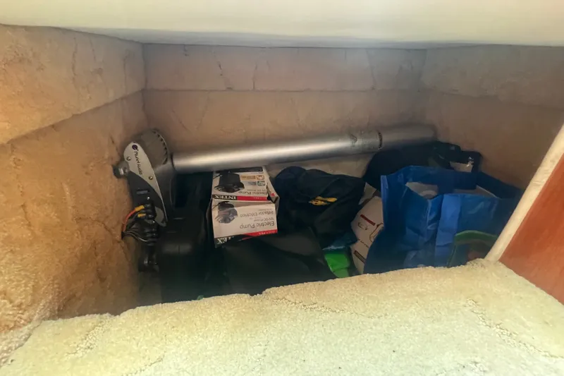 Slide: The Image of Storage compartment in a 2004 Rinker 282 Captiva Bowrider with various boating equipment. - 27