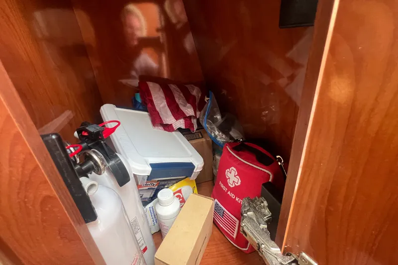 Slide: The Image of Storage compartment in a 2004 Rinker 282 Captiva Bowrider with safety equipment and supplies. - 28