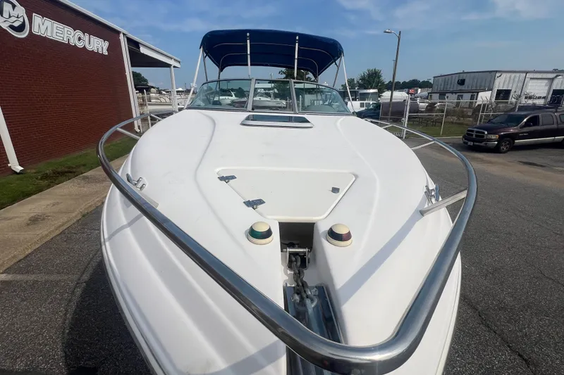 Slide: The Image of 2004 Rinker 282 Captiva Bowrider boat with blue canopy, parked near Mercury building. - 14