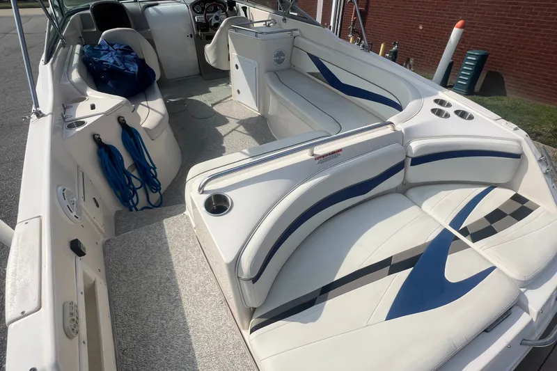Slide: The Image of 2004 Rinker 282 Captiva Bowrider interior with white and blue seating, cup holders, and ropes. - 16