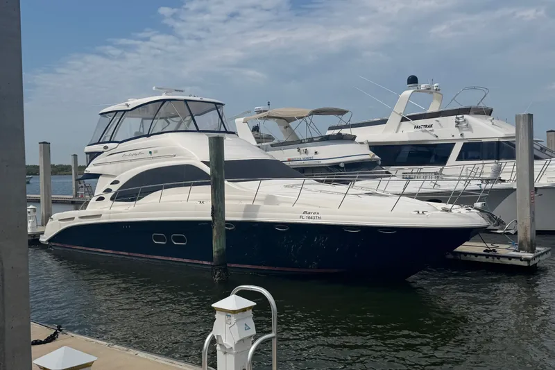 Slide: The Image of 2006 Sea Ray 550 Sedan Bridge yacht docked at marina under cloudy sky. - 43