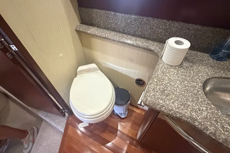 Slide: The Image of Bathroom interior of 2006 Sea Ray 550 Sedan Bridge yacht with toilet and granite countertop. - 85
