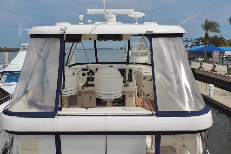Slide: The Image of 2006 Sea Ray 550 Sedan Bridge yacht at dock, featuring enclosed helm and seating area. - 20