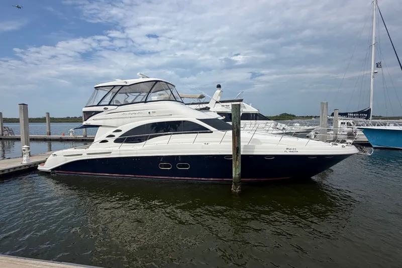 Slide: The Image of 2006 Sea Ray 550 Sedan Bridge yacht docked at marina under cloudy sky. - 44