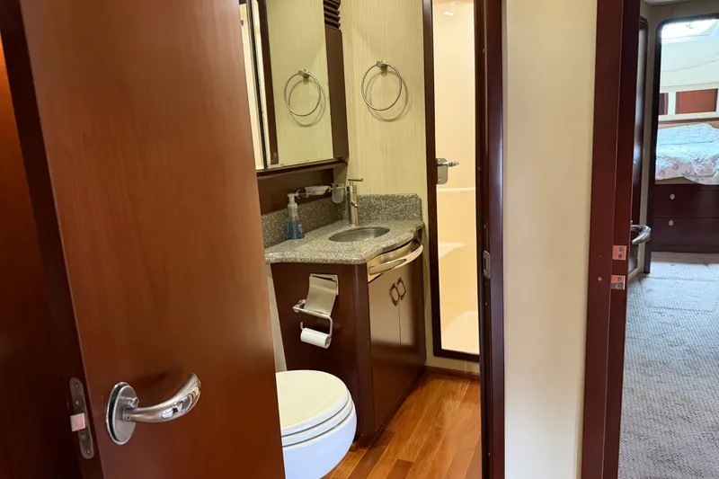Slide: The Image of Bathroom interior of 2006 Sea Ray 550 Sedan Bridge yacht, featuring wood accents and modern fixtures. - 119