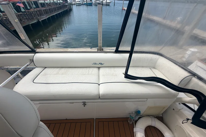 Slide: The Image of 2006 Sea Ray 550 Sedan Bridge interior with white seating and marina view. - 55