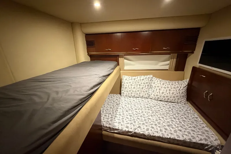 Slide: The Image of Interior cabin of 2006 Sea Ray 550 Sedan Bridge with bunk beds and wooden cabinets. - 126