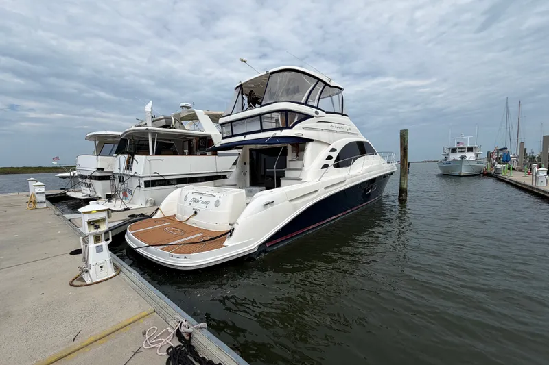 Slide: The Image of 2006 Sea Ray 550 Sedan Bridge yacht docked at marina under cloudy sky. - 42