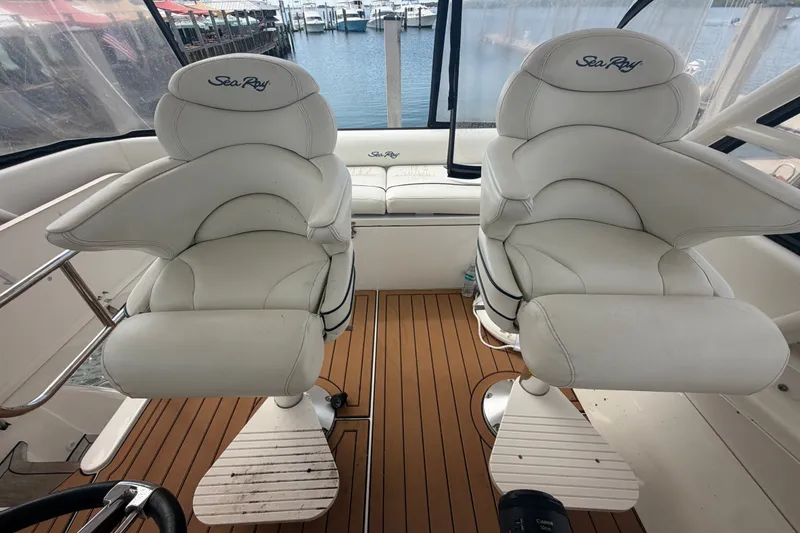 Slide: The Image of Luxury helm seats on 2006 Sea Ray 550 Sedan Bridge yacht, overlooking marina. - 53