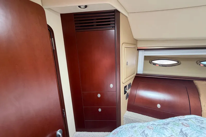 Slide: The Image of Luxurious 2006 Sea Ray 550 Sedan Bridge cabin interior with wood finish and porthole windows. - 134