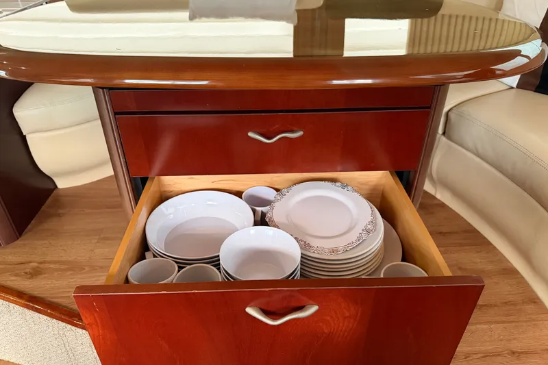 Slide: The Image of Open drawer with neatly stacked white dishes and cups on a 2006 Sea Ray 550 Sedan Bridge. - 110