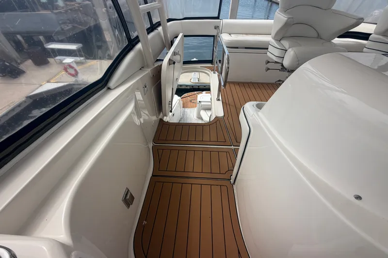 Slide: The Image of 2006 Sea Ray 550 Sedan Bridge interior with teak flooring and white seating. - 60