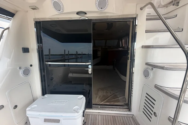 Slide: The Image of 2006 Sea Ray 550 Sedan Bridge yacht entrance with stairs and cooler on deck. - 48