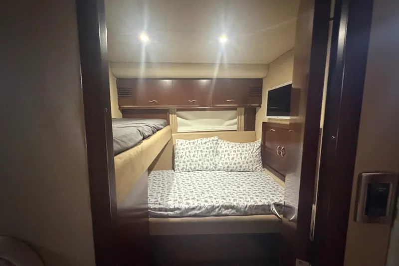Slide: The Image of Interior cabin of 2006 Sea Ray 550 Sedan Bridge with cozy bedding and wooden cabinetry. - 95