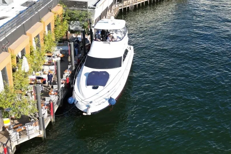Slide: The Image of 2006 Searay Sedan Bridge yacht docked beside waterfront restaurant. - 1