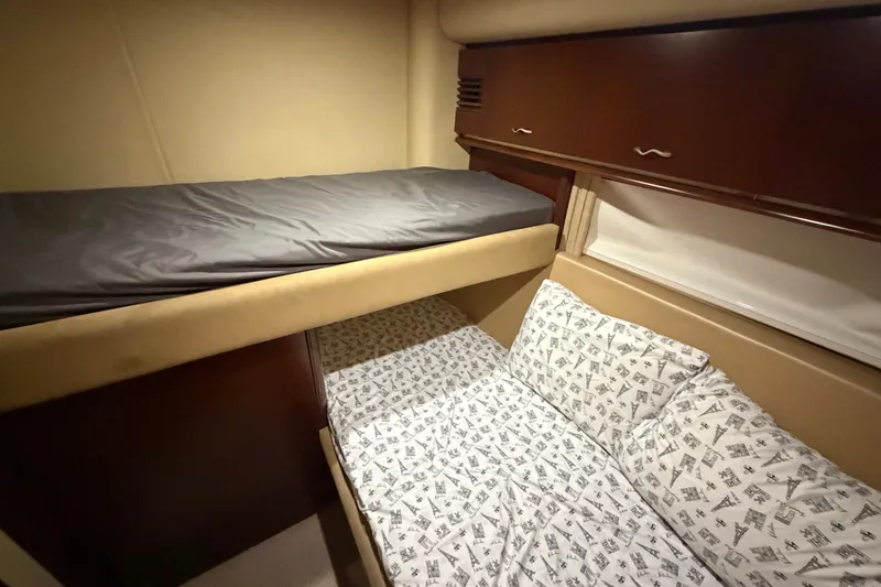 Slide: The Image of 2006 Sea Ray 550 Sedan Bridge cabin with bunk beds and patterned bedding. - 129