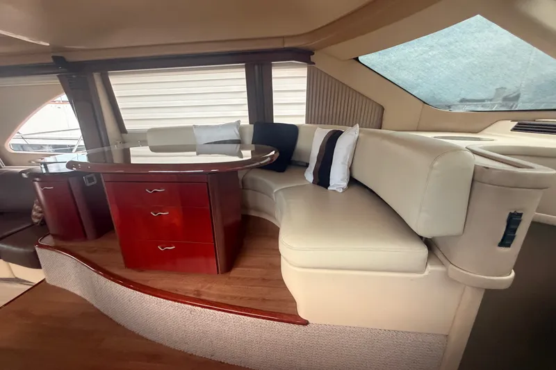 Slide: The Image of Luxurious interior of 2006 Sea Ray 550 Sedan Bridge with elegant seating and wooden table. - 69