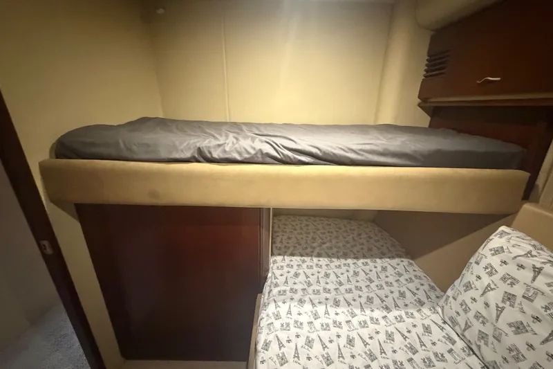 Slide: The Image of Bunk beds in 2006 Sea Ray 550 Sedan Bridge yacht cabin, featuring cozy bedding. - 98