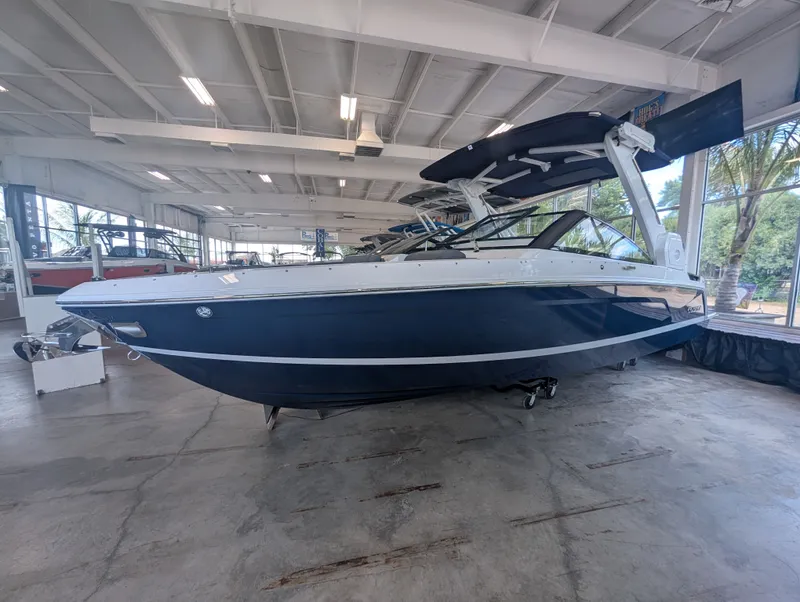 The Image of A sleek, modern boat with a blue hull and white deck is in a spacious showroom. - 1