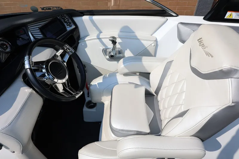 Slide: The Image of Interior of a 2013 Tigé Z3 boat featuring a sleek steering wheel and plush seating. - 41