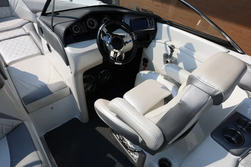 Slide: The Image of Interior of a 2013 Tigé Z3 boat featuring a sleek steering wheel and plush seating. - 39