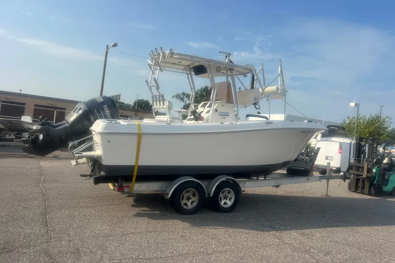 Slide: The Image of 2007 Clearwater 2300 Center Console boat on trailer, parked outdoors under clear sky. - 3