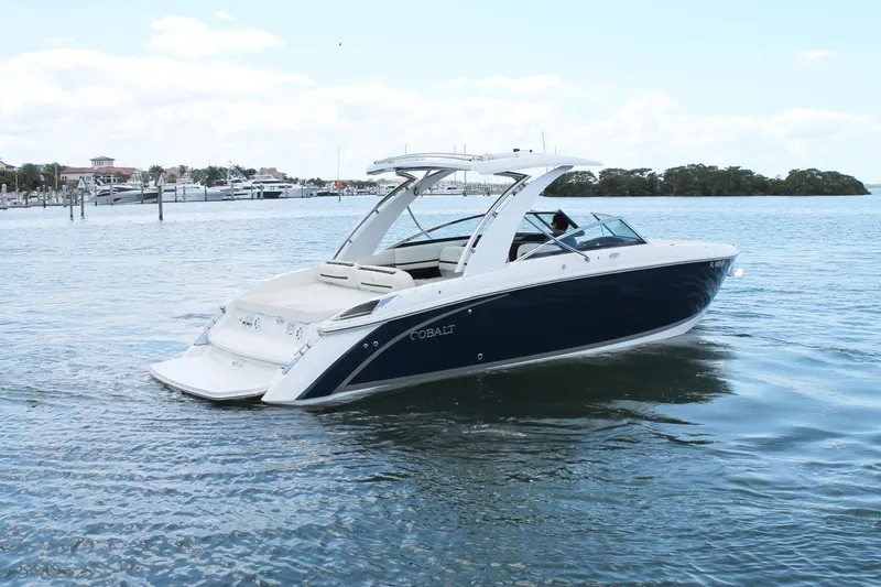 Slide: The Image of 2017 Cobalt R30 boat cruising on calm waters near a marina. - 11