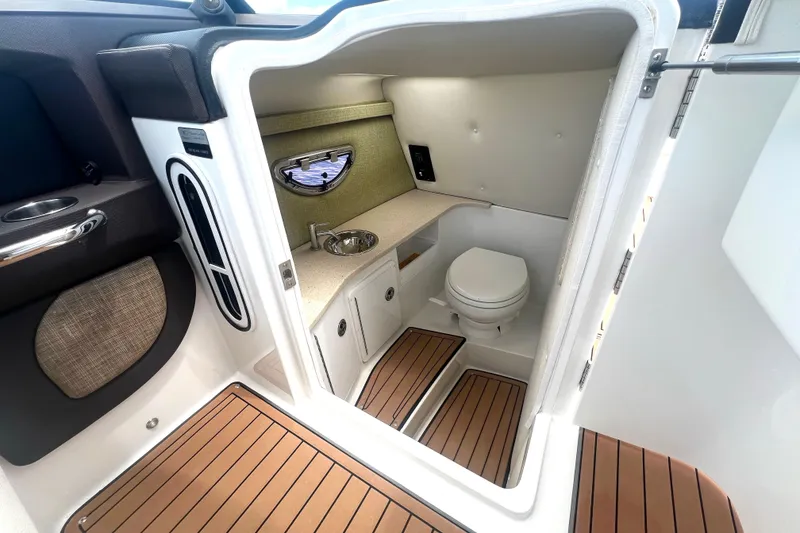 Slide: The Image of 2017 Cobalt R30 boat interior with compact bathroom, featuring a toilet and sink. - 24